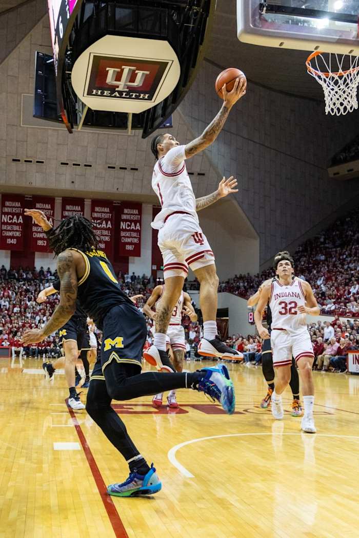 Jalen Hood-Schifino (1) shoots the ball while Michigan Wolverines guard Ian Burns (4) defends.
